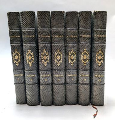 six vieux livres sont alignés sur une surface blanche