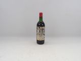 une vieille bouteille de vin posée sur une table blanche