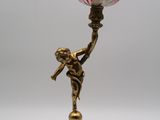 un bougeoir ancien en laiton avec un abat-jour en verre rouge