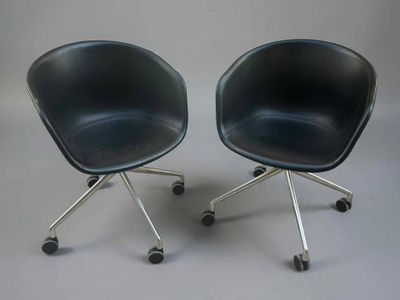 deux chaises noires à roulettes posées sur une surface grise