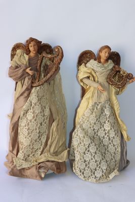 Deux figurines d'anges sont placées l'une à côté de l'autre sur une surface blanche