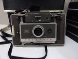 a polaroid camera sitting on a table with a strap around it