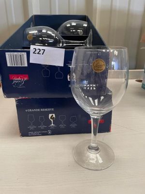 un verre à vin posé sur une table à côté d'une boîte de verres à vin