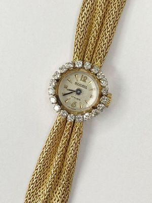 an image of a woman ' s wrist watch with a chain around it