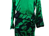 a green and black dress sitting on top of a mannequin mannequin
