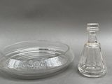une bouteille en verre et un saladier en verre posés sur une table