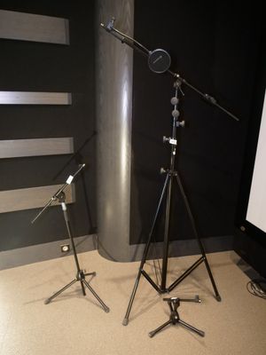deux microphones et un trépied placés devant un écran de projection