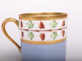 une tasse à café avec un bord doré et un fond bleu