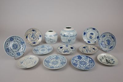several blue and white plates and vases are arranged on a table