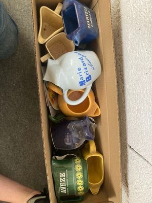 une boîte remplie de tasses à café posée par terre
