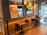 tables and chairs in a restaurant with a bar in the background