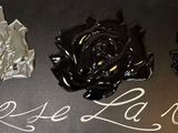three roses that are sitting on a black table