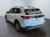the rear end of a white volkswagen suv parked in a showroom