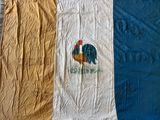 deux serviettes avec des coqs sur une couverture bleue et blanche