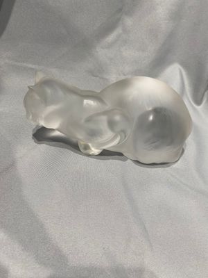 un objet en verre posé sur un tissu blanc, sur une table