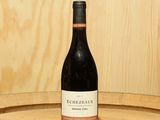 une bouteille de vin posée sur un tonneau