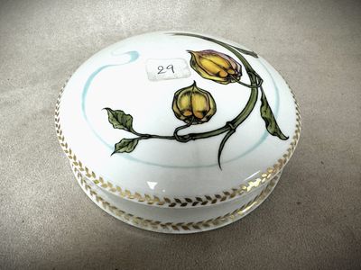 une boîte blanche ornée de fleurs jaunes, posée sur une table