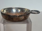 un bol en argent posé sur un socle transparent, sur une table
