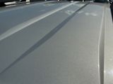 a close up of a car ' s hood with a car in the background