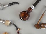 many different types of smoking pipes on the table