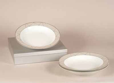 deux assiettes et un bol posés sur une boîte blanche