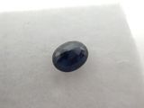 a blue sapphire stone on a white surface