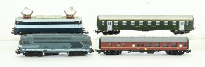 quatre petits trains jouets posés les uns à côté des autres sur une surface blanche