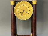 a clock that is sitting on top of a wooden stand
