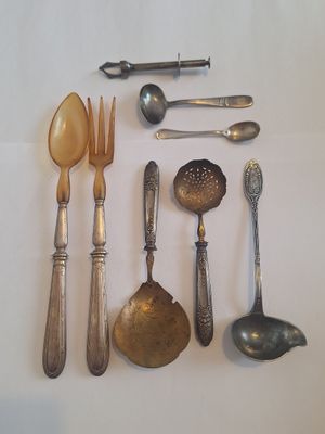 de nombreuses cuillères, fourchettes et cuillères-fourchettes disposées sur une table