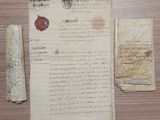 un morceau de papier portant un cachet de cire et un morceau de papier sur lequel est apposé un cachet de cire