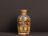 a small vase with a painting on it sitting on a table