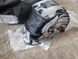 a helmet on the ground next to a bag of luggage
