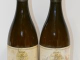 two bottles of wine sitting on a table next to each other