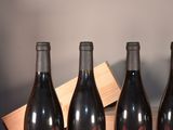 four bottles of wine are lined up on a table