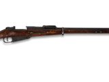 un fusil avec un canon en bois sur fond blanc