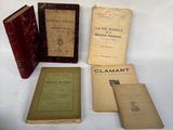 several old books are sitting on a table with a white background