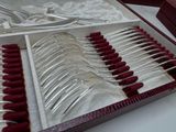 many forks and spoons in a box on a table