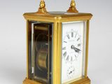 a gold clock that is sitting on a white surface