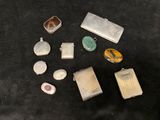 several different types of silver and glass items on a black surface