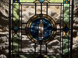 a stained glass window in the corner of a stone wall