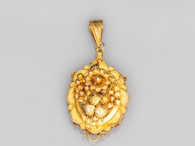 un pendentif en or orné d'une grappe de raisin au centre