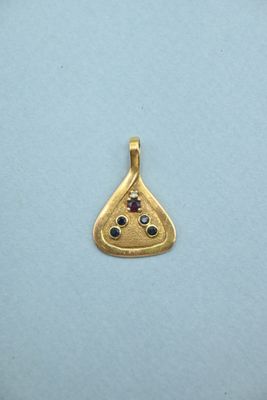 a close up of a gold plated pendant with a slice of pizza on it