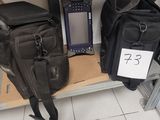 un sac et un téléphone portable posés sur une étagère dans une pièce