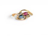 a close up of a gold ring with a pink and blue stone