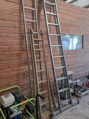 deux échelles appuyées contre un mur en bois dans une pièce
