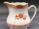an orange and white pitcher sitting on top of a table