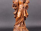 une statue en bois représentant une femme tenant un enfant