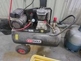 un petit compresseur d'air posé sur un chariot dans un garage