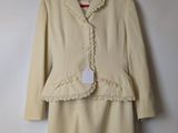 beige dress and jacket with lace trim on hanger on wall
