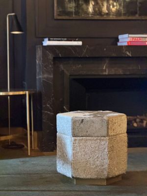 a stone block sitting on the floor in front of a fire place